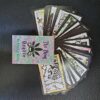 Cannabis Phrog Oracle Deck Cards spread in fan, face up, with card box in center.